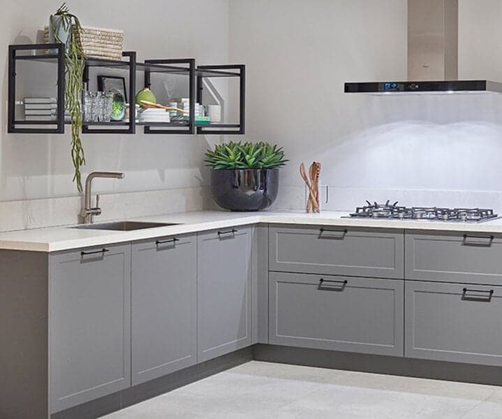 Grijze landelijke hoekkeuken met kaderdeuren